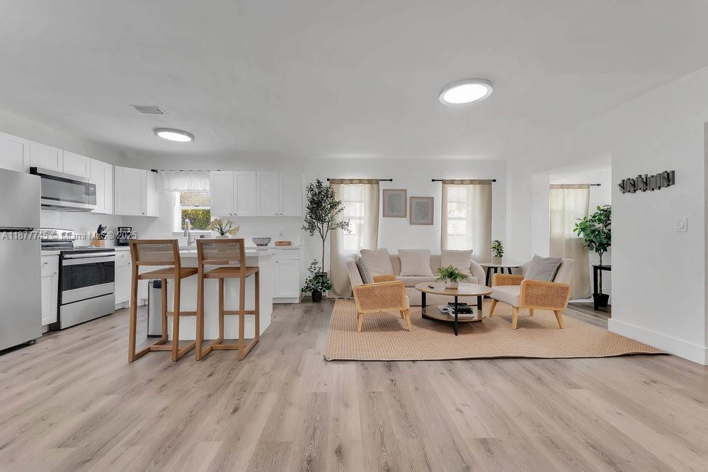 180 Northwest 69th Street Miami, FL 33150 - Photo 7 of 31 a living room with furniture and a wooden floor