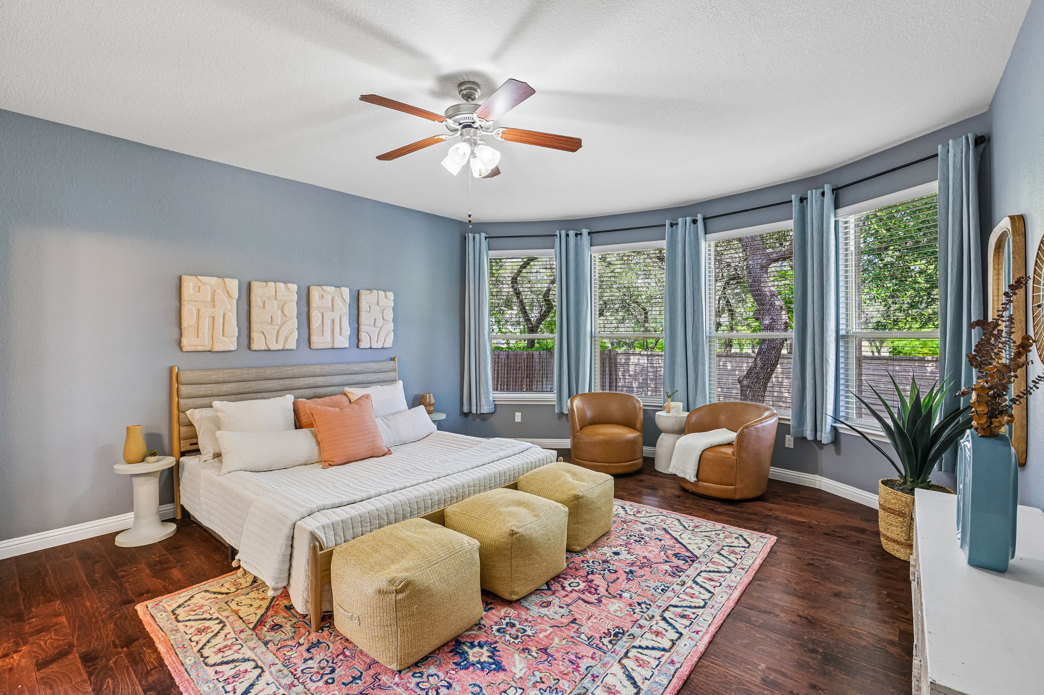 1924 Granite Springs Road Leander, TX 78641 - Photo 14 of 36 Rich hardwood floors complement a spacious primary bedroom with bay windows offering treetop views.