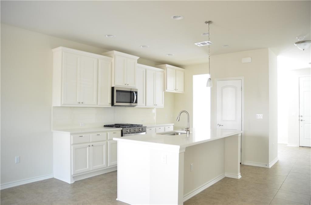 14403 McCoy Loop Austin, TX 78717 - Photo 7 of 29 Bright, naturally illuminated kitchen features a large island and ample cabinet storage.