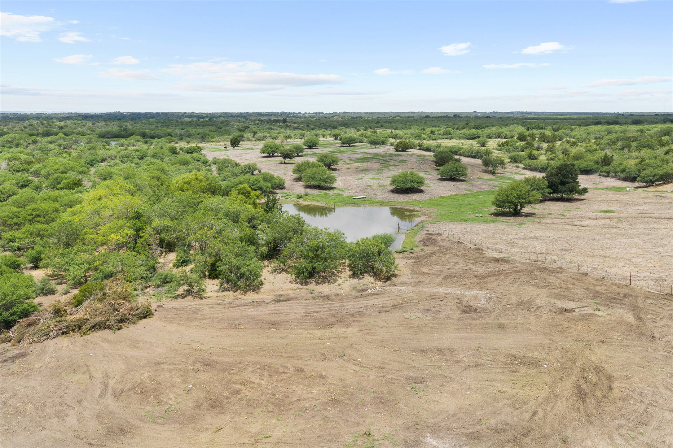 3315 Dry Creek Road Lockhart, TX 78644 - Photo 8 of 26 A tranquil pond and lush vegetation define this expansive rural lot, perfect for a secluded retreat.