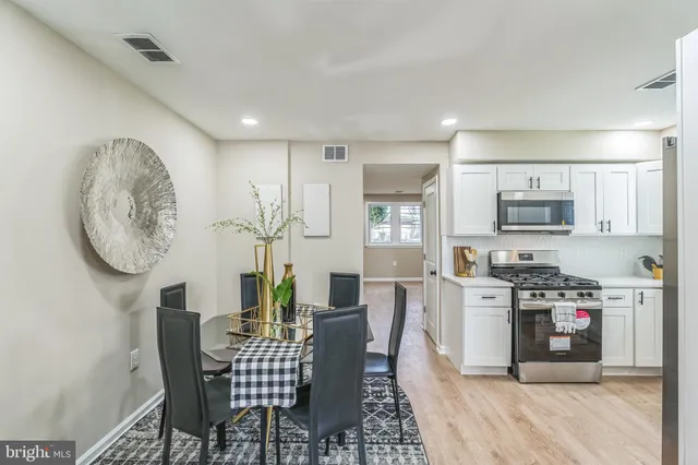 a living room with furniture a flat screen tv and kitchen view