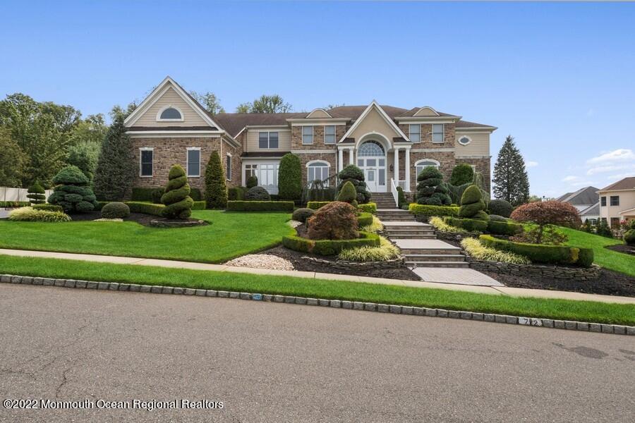 a front view of a house with a yard and potted plants