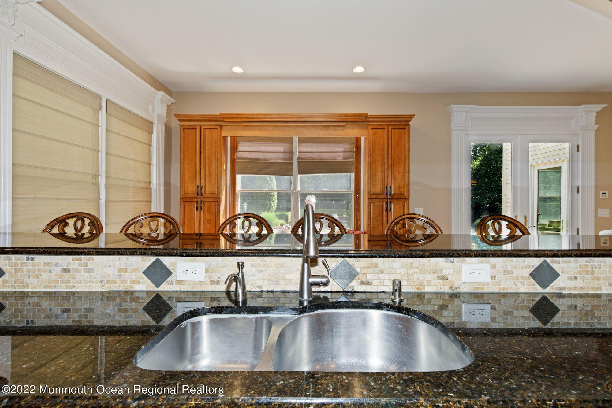 72 Edgewood Road Morganville, NJ 07751 - Photo 31 of 86 a kitchen sink with a granite countertop a sink and white cabinets next to a window
