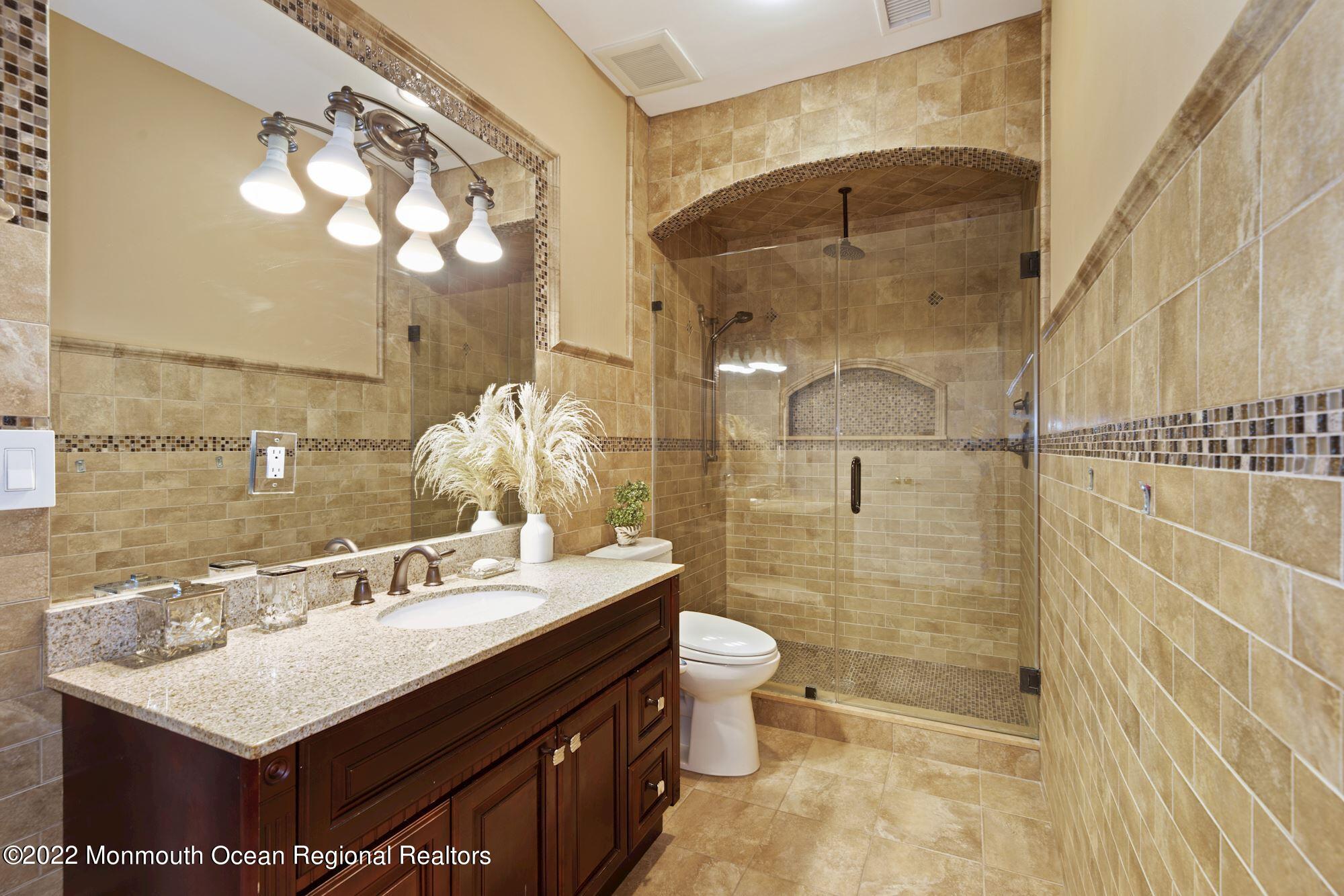 72 Edgewood Road Morganville, NJ 07751 - Photo 54 of 86 a bathroom with a sink mirror and a shower