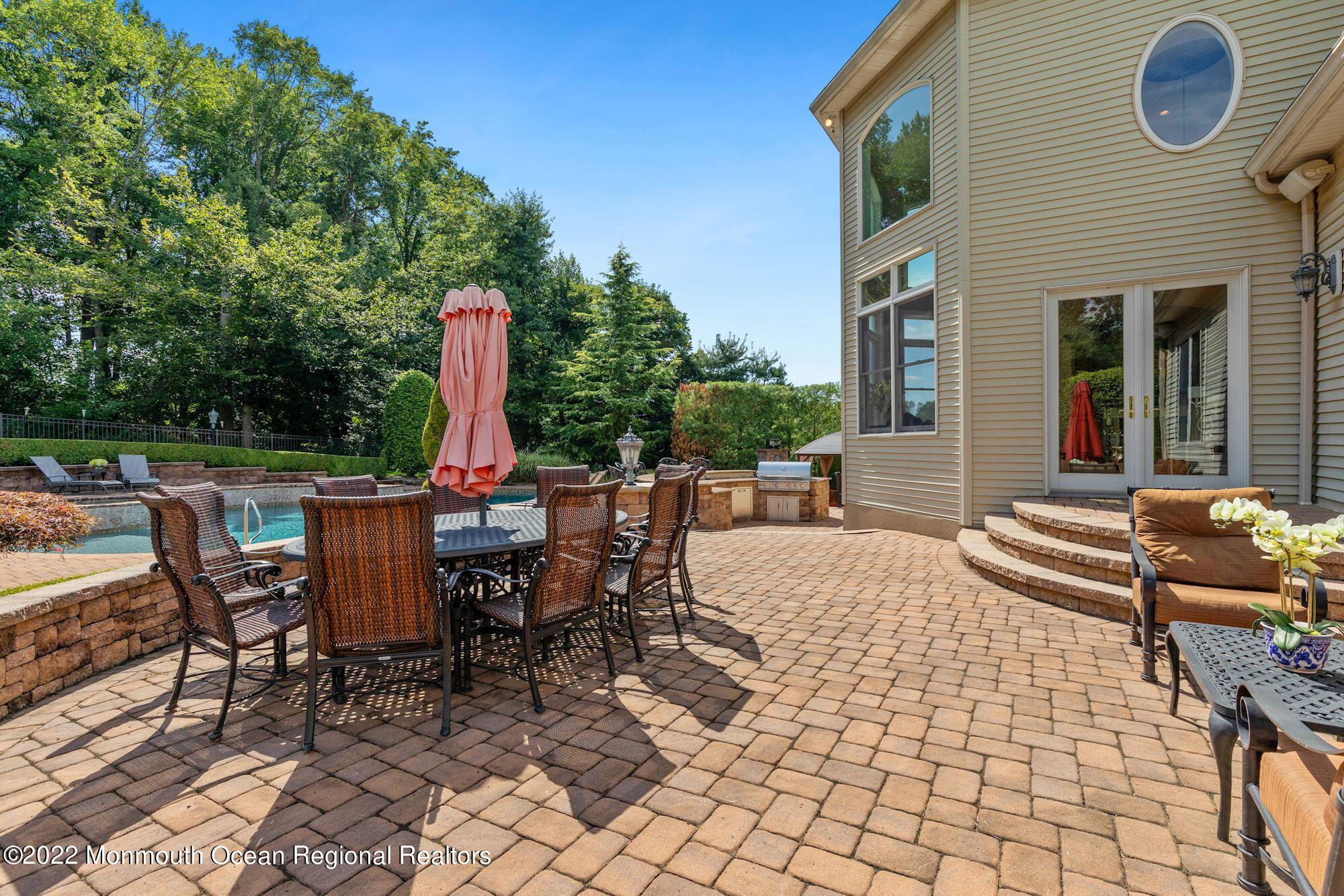 72 Edgewood Road Morganville, NJ 07751 - Photo 57 of 86 a view of a patio with a dining table and chairs with wooden fence