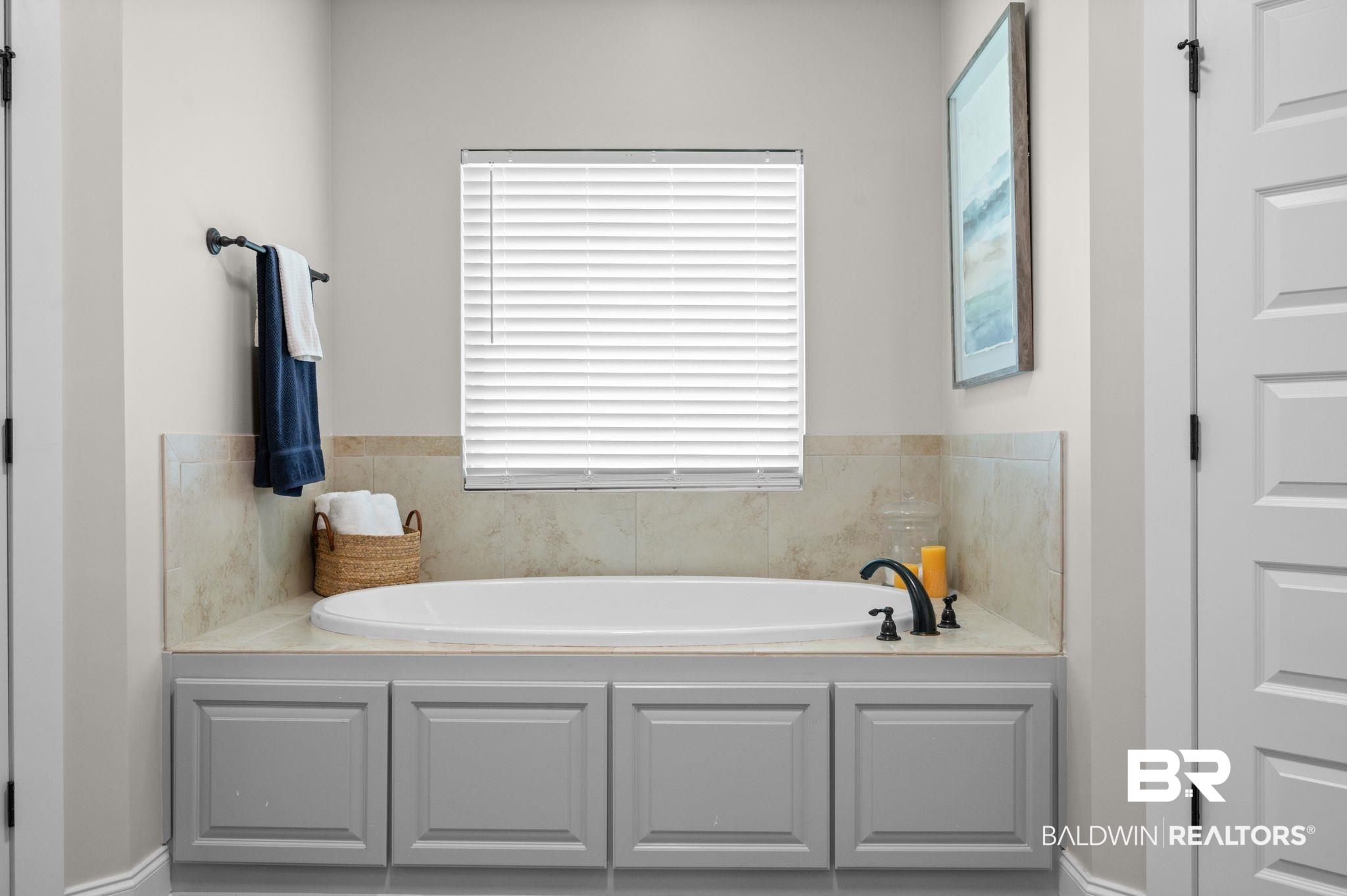 409 Fortune Drive Fairhope, AL 36532 - Photo 20 of 42 Built-in soaking tub with black fixtures, surrounded by light-toned tile and a coordinated cabinetry base