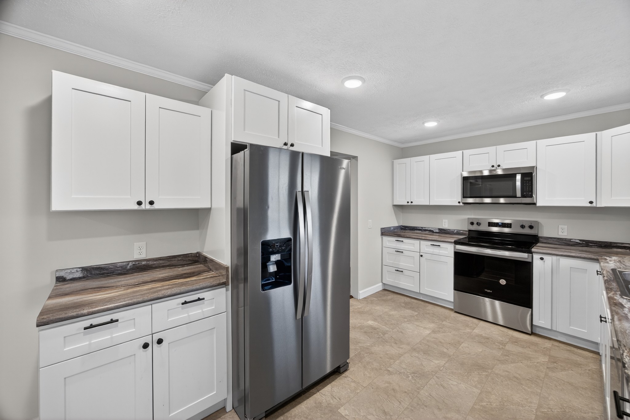 2136 West Broad Street Cookeville, TN 38501 - Photo 11 of 33 a kitchen with granite countertop white cabinets and stainless steel appliances