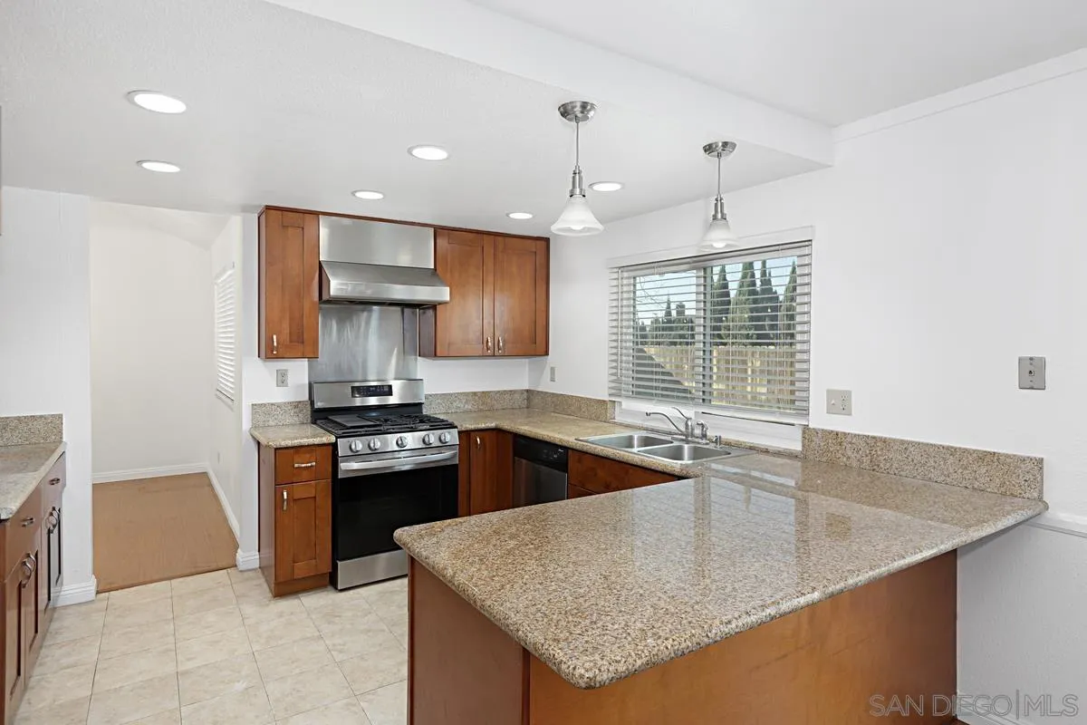 10148 East Glendon Circle Santee, CA 92071 - Photo 11 of 33 a kitchen with stainless steel appliances granite countertop a sink stove and refrigerator