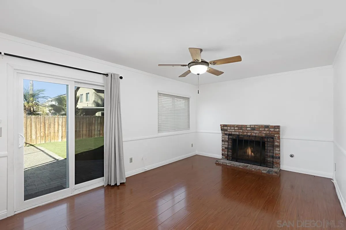 10148 East Glendon Circle Santee, CA 92071 - Photo 9 of 33 an empty room with wooden floor fireplace and windows