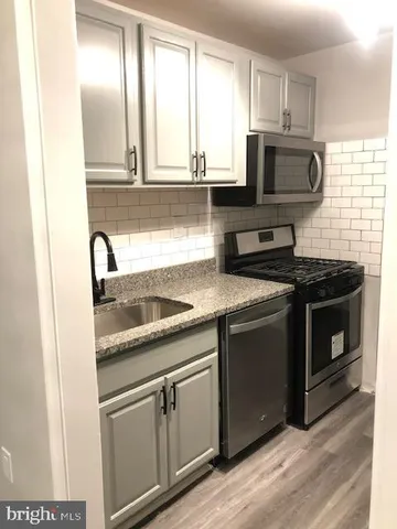 a kitchen with granite countertop white cabinets and appliances