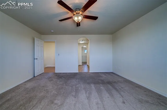 an empty room with fan and windows