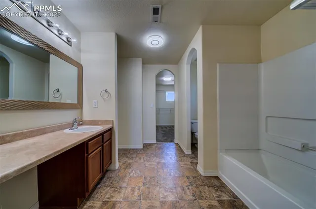 a bathroom with a tub sink and mirror
