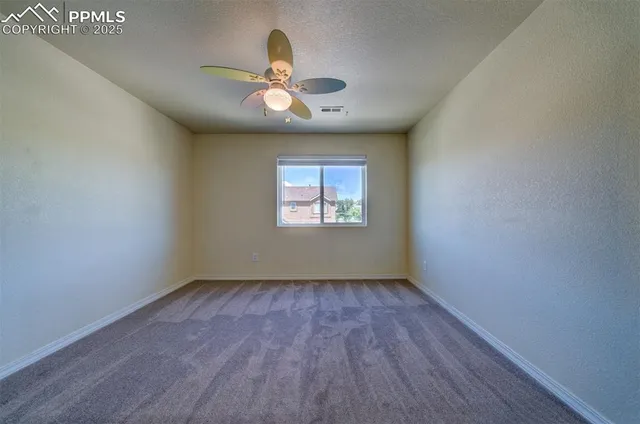an empty room with wooden floor chandelier and window