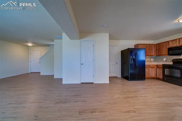 a view of kitchen with refrigerator and wooden floor