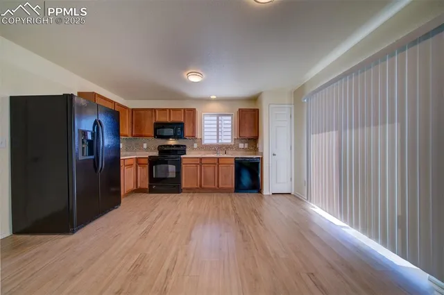 a kitchen with stainless steel appliances granite countertop a refrigerator oven a sink dishwasher and a stove with wooden floor