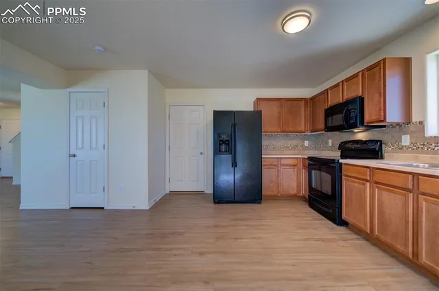 a kitchen with stainless steel appliances granite countertop a stove a sink dishwasher a refrigerator and a microwave oven