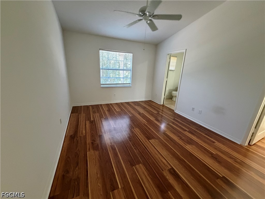 8541 Athena Court Lehigh Acres, FL 33971 - Photo 12 of 17 wooden floor in an empty room with a window