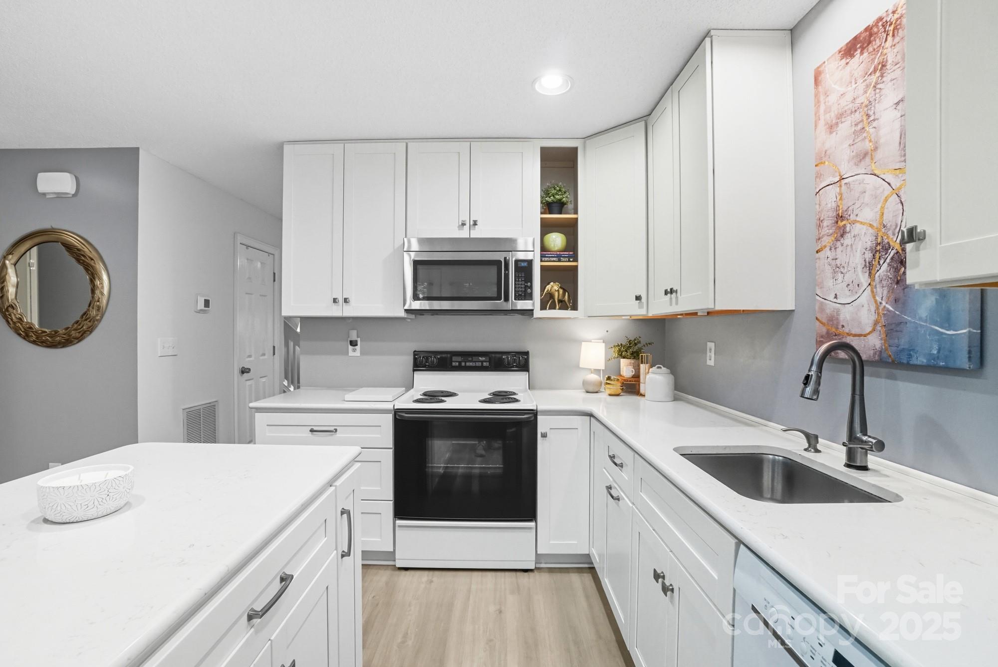 9166 Exbury Court Charlotte, NC 28269 - Photo 14 of 31 a kitchen with a sink dishwasher a stove top oven a refrigerator with white cabinets and wooden floor