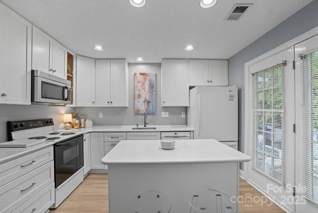 a kitchen with a sink a stove a refrigerator and cabinets