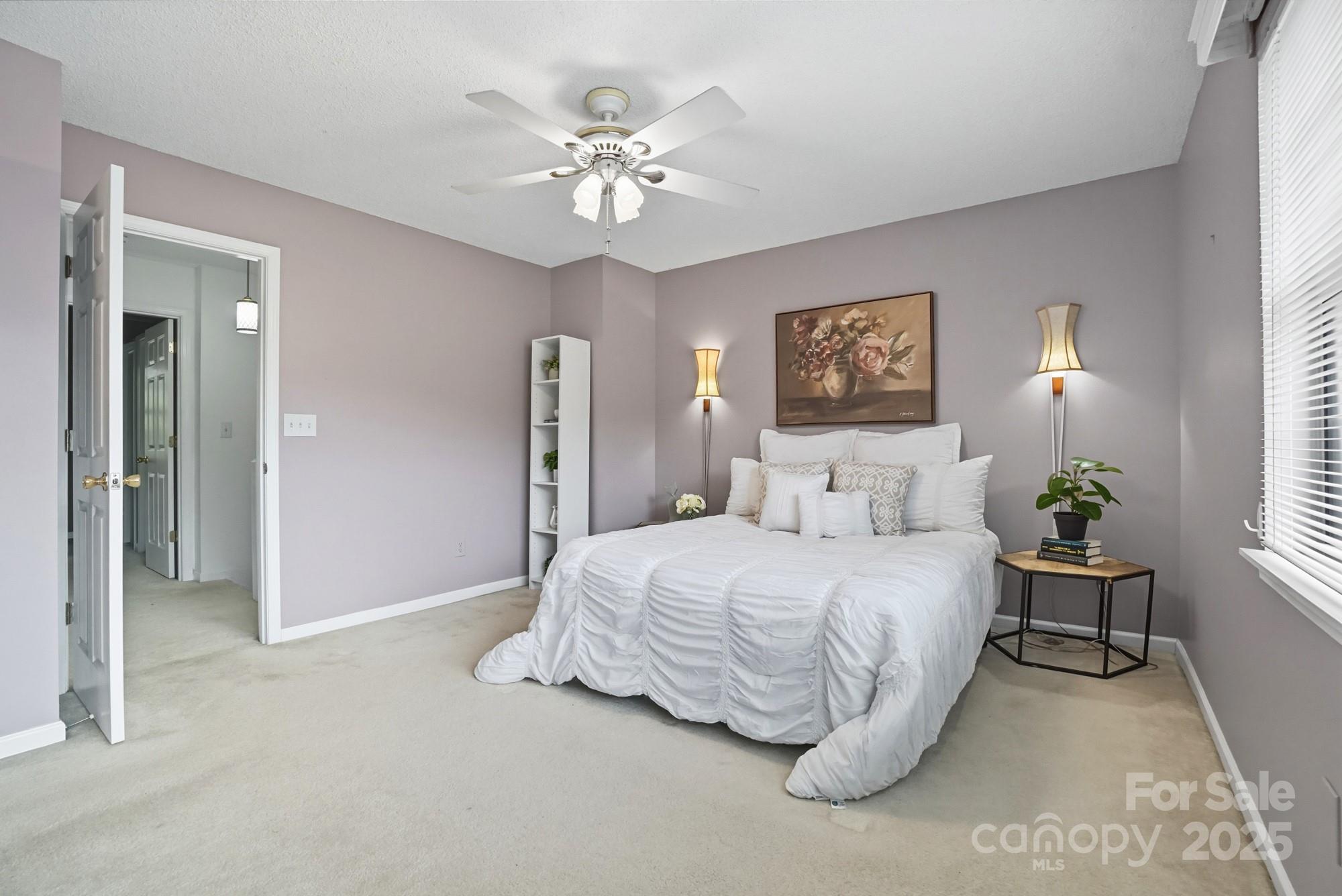 9166 Exbury Court Charlotte, NC 28269 - Photo 20 of 31 a spacious bedroom with a bed and a chandelier