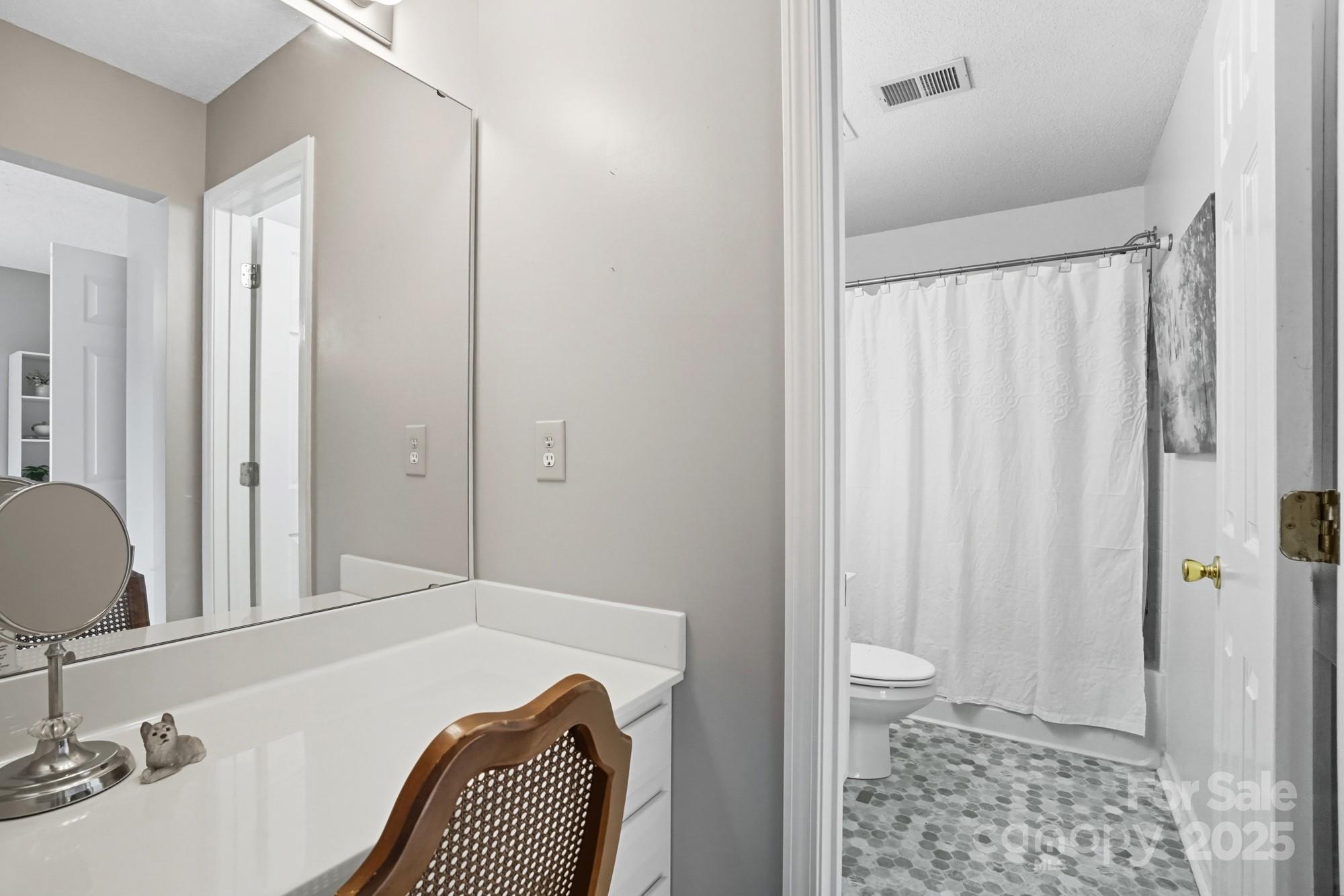 9166 Exbury Court Charlotte, NC 28269 - Photo 22 of 31 a bedroom with a bed and a chair