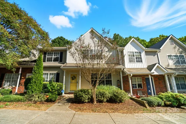 front view of a brick house with a small yard