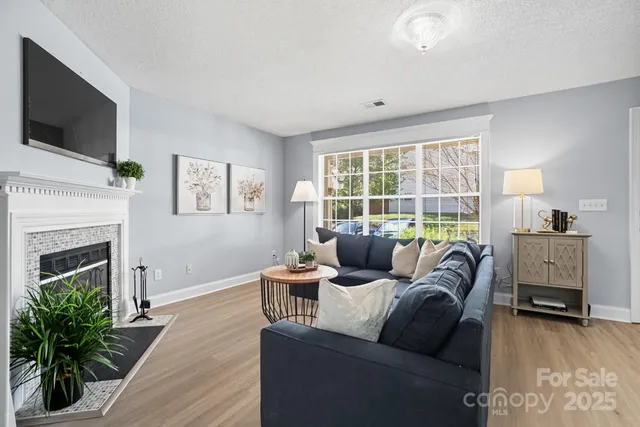 a living room with furniture a flat screen tv and a fireplace