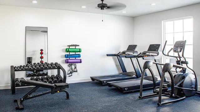 a room with gym equipment and windows
