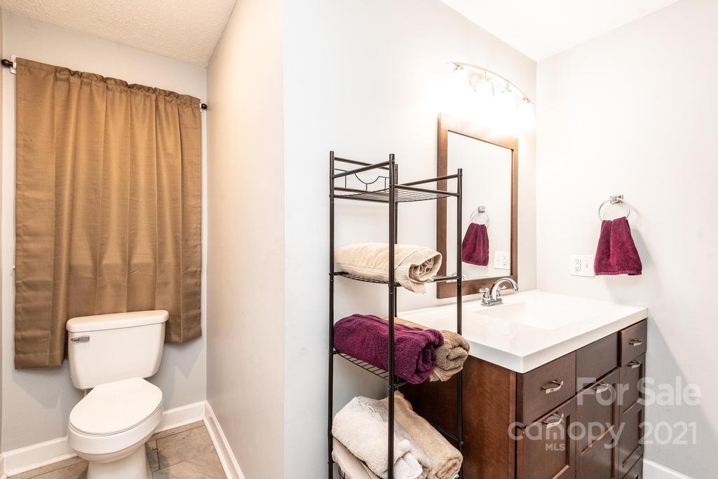 5196 Jenkins Road Morganton, NC 28655 - Photo 27 of 46 a bathroom with a toilet sink vanity and mirror