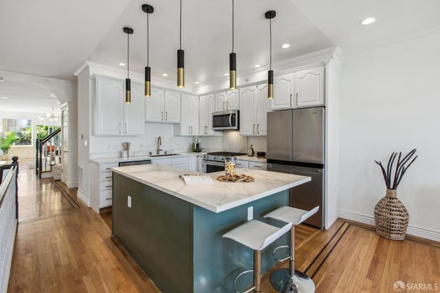 a kitchen with a sink refrigerator and cabinets