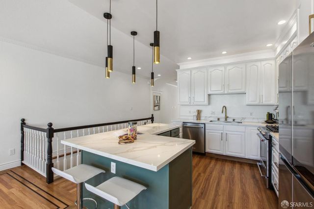 a kitchen with white cabinets and stainless steel appliances