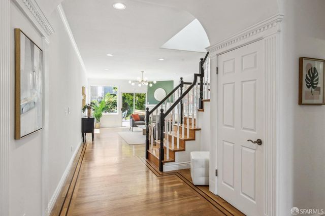 a view of a hallway with wooden floor and a living room
