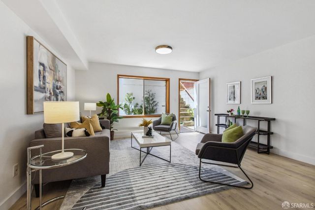 a living room with furniture and view of kitchen