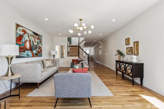 a living room with furniture and a wooden floor