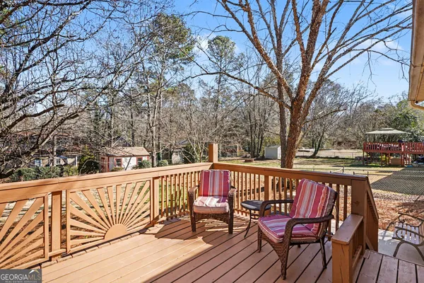 a balcony with wooden floor table and chairs
