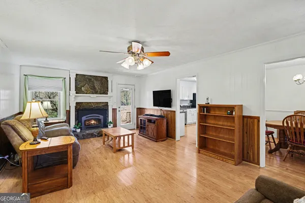 a view of a dining room with furniture a chandelier and wooden floor