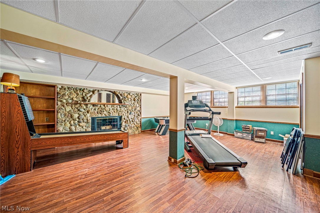 8801 Bunker Road Orwell, OH 44076 - Photo 45 of 50 Workout area featuring a drop ceiling, wood finished floors, a fireplace, and wainscoting