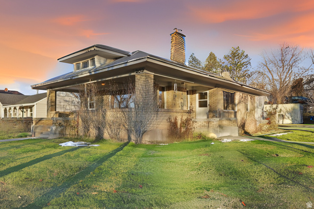 202 Main Street Smithfield, UT 84335 - Photo 2 of 32 Back of property at dusk with a lawn, brick siding, and a chimney