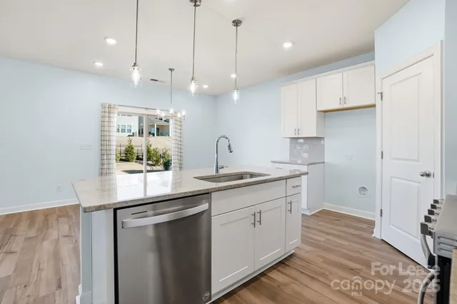 a kitchen with kitchen island a sink stainless steel appliances and cabinets