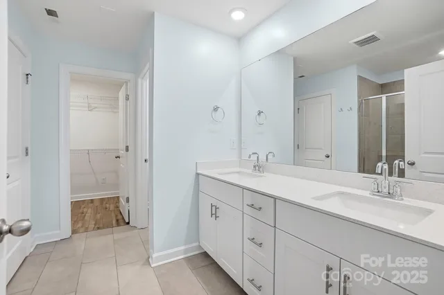 a spacious bathroom with double sink and a mirror