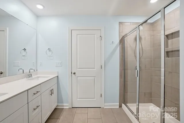 a spacious bathroom with a shower sink and mirror