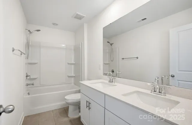 a bathroom with a granite countertop toilet a sink and a bathtub
