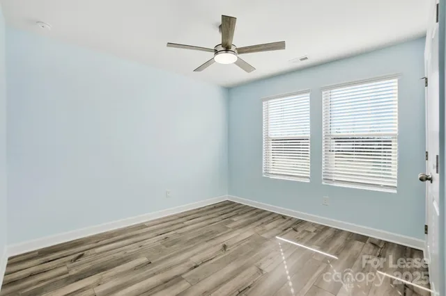 a view of a room with a ceiling fan and a window