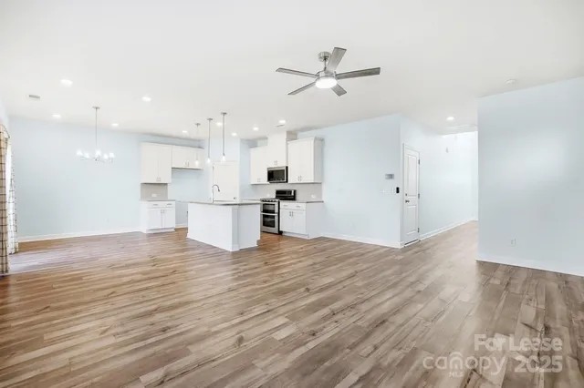 a view of a kitchen with a dishwasher kitchen stove cabinets and wooden floor