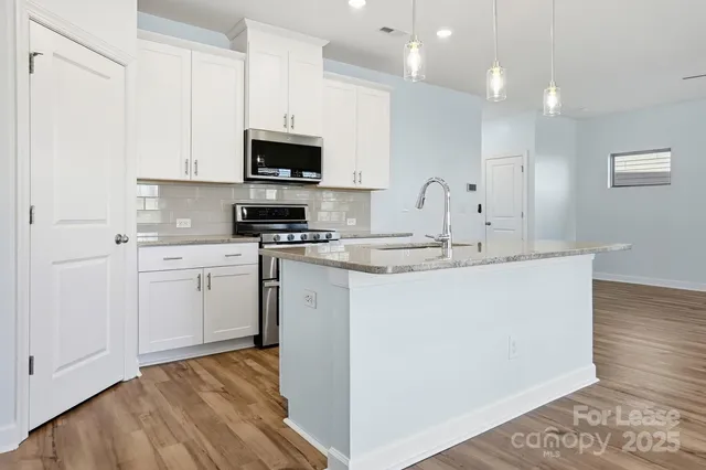 a kitchen with white cabinets appliances and sink