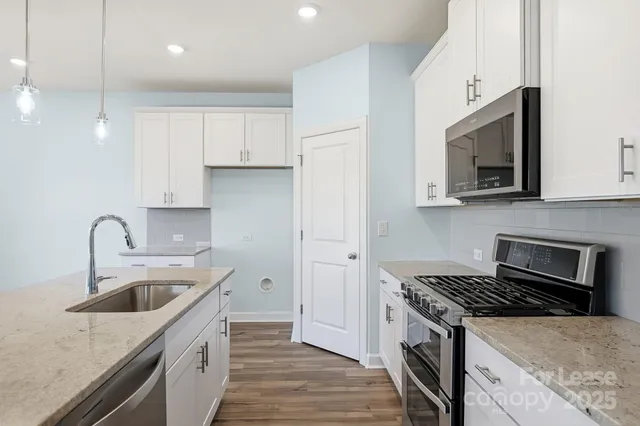 a kitchen with a sink stove top oven and cabinets