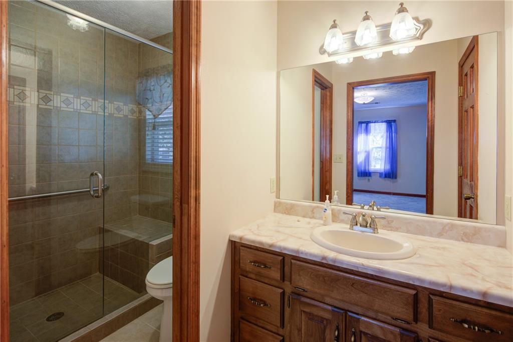 4920 McCoy Circle Cumming, GA 30040 - Photo 11 of 31 a bathroom with a shower sink and mirror