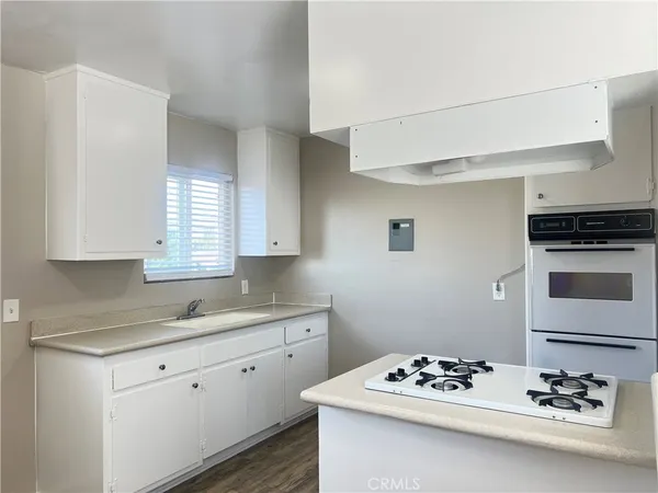 a kitchen with stainless steel appliances kitchen island a white stove top oven and cabinets