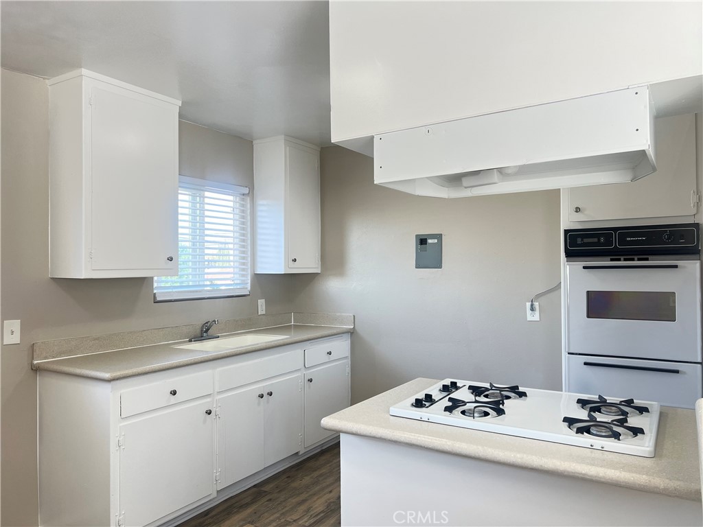 a kitchen with stainless steel appliances kitchen island a white stove top oven and cabinets