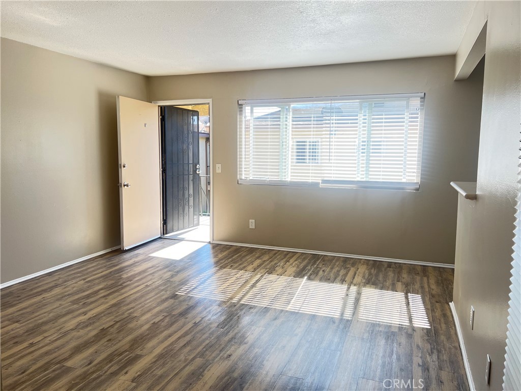 4920 Maine Avenue, Unit M Baldwin Park, CA 91706 - Photo 3 of 17 an empty room with wooden floor and windows
